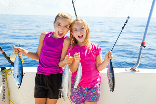 Photo: Happy tuna fisherwomen kid girls with fishes catch Happy tuna fisherwomen kid girls with fishes catch