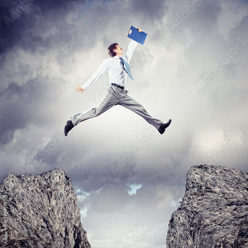 Photo: Businessman jumping over gap Businessman jumping over gap