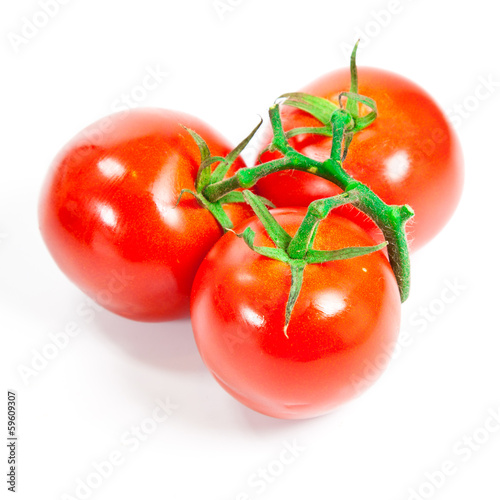 Photo: Closeup of tomatoes on the vine isolated on white Closeup of tomatoes on the vine isolated on white