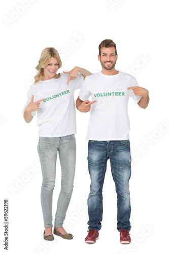Photo: Portrait of two happy volunteers pointing to themselves Portrait of two happy volunteers pointing to themselves