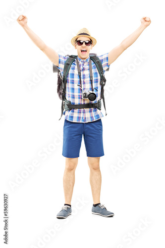 Photo: Smiling male hiker with raised hands gesturing happiness Smiling male hiker with raised hands gesturing happiness