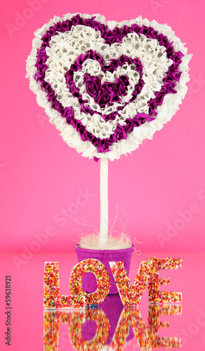 Photo: Decorative heart from paper on pink background Decorative heart from paper on pink background