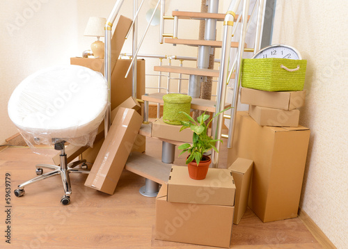 Photo: Stack of cartons near stairs: moving house concept Stack of cartons near stairs: moving house concept