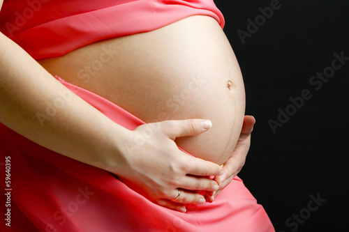 Photo: Pregnant woman with coral material isolated on black Pregnant woman with coral material isolated on black