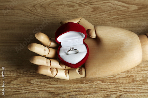 Photo: Ring in wooden hand isolated on white Ring in wooden hand isolated on white