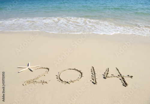 Photo: Year 2014 hand written on the white sand in front of the sea Year 2014 hand written on the white sand in front of the sea