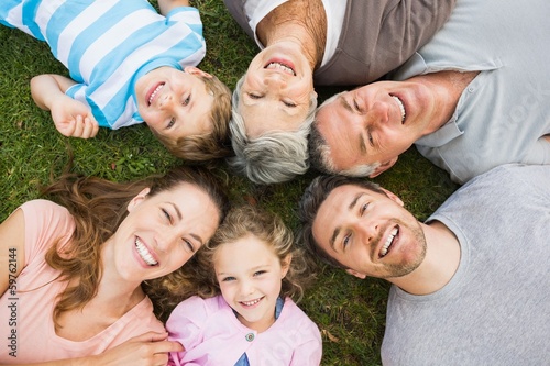 Photo: Extended family lying in circle at park Extended family lying in circle at park
