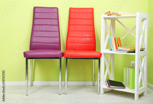 Photo: Beautiful interior with modern color chairs, books Beautiful interior with modern color chairs, books