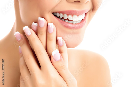 Photo: Face, hands and healthy white teeth of a woman Face, hands and healthy white teeth of a woman
