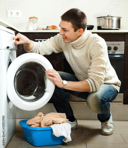 Photo: Man loading the washing machine Man loading the washing machine