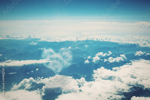 Photo: Heart shaped cloud on blue sunny sky. Heart shaped cloud on blue sunny sky.