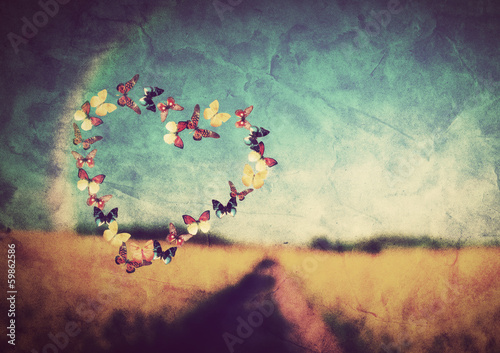 Photo: Heart shape made of butterflies on vintage field background Heart shape made of butterflies on vintage field background