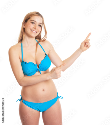 Photo: Frau im blauen Bikini zeigt zur Seite Frau im blauen Bikini zeigt zur Seite