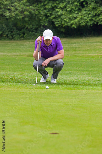 Photo: Golfer reading the green Golfer reading the green