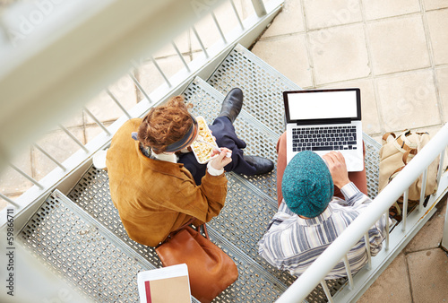 Photo: Hipster couple using computer and eating lunch outdoors Hipster couple using computer and eating lunch outdoors