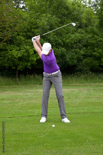 Photo: Golfer playing a mid iron shot Golfer playing a mid iron shot