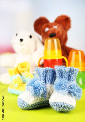 Photo: Composition with crocheted booties for baby, bottle, toy and Composition with crocheted booties for baby, bottle, toy and