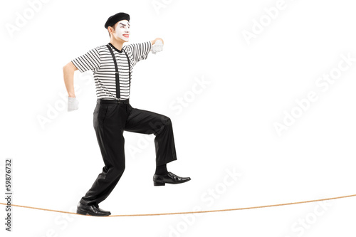 Photo: Full length portrait of a male mime artist walking on a rope Full length portrait of a male mime artist walking on a rope