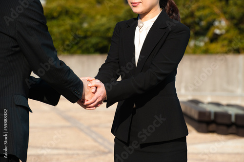 Photo: スーツ姿で握手する二人 スーツ姿で握手する二人