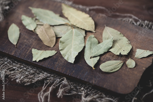 Photo: Dried bay leaves on a vintage wooden cutting board Dried bay leaves on a vintage wooden cutting board