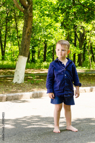 Photo: Handsome barefoot little boy standing waiting Handsome barefoot little boy standing waiting