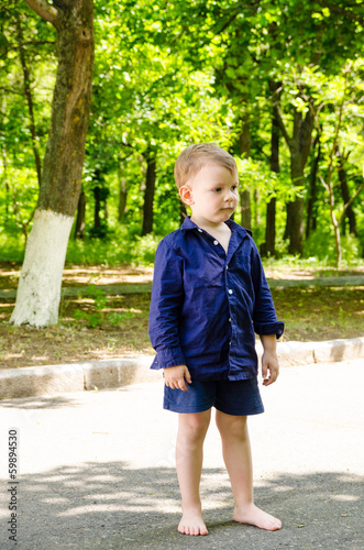 Photo: Handsome barefoot little boy standing waiting Handsome barefoot little boy standing waiting