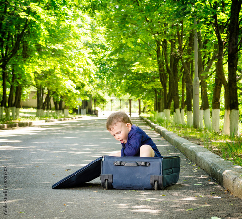 Photo: Young boy playing with an open suitcase Young boy playing with an open suitcase