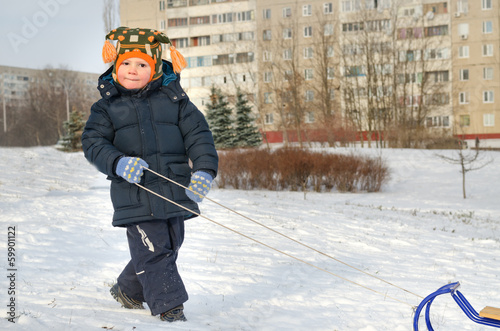 Photo: Cute little boy pulling his sled Cute little boy pulling his sled