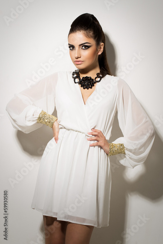 Photo: Vogue. Beautiful woman posing in white dress Vogue. Beautiful woman posing in white dress