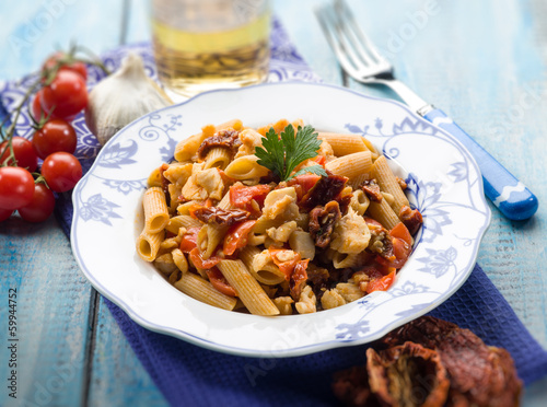Photo: pasta with fish ragout and dried tomatoes, selective focus pasta with fish ragout and dried tomatoes, selective focus