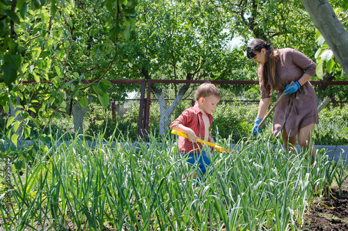 Photo: Small boy helping his mother in the garden Small boy helping his mother in the garden