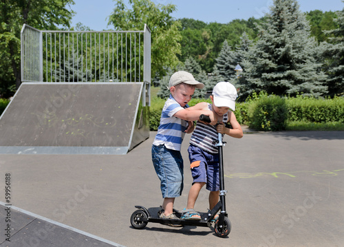 Photo: Two small boys arguing over a scooter Two small boys arguing over a scooter
