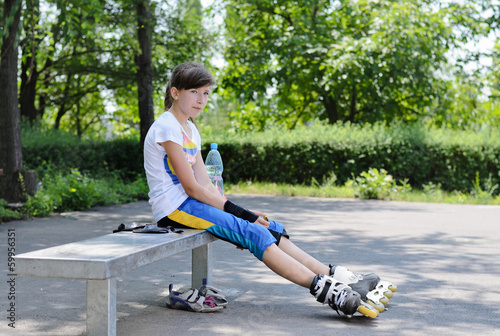 Photo: Cute teenager sitting and relaxing during skating Cute teenager sitting and relaxing during skating