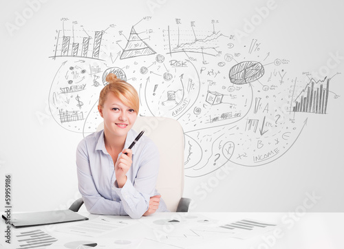 Photo: Business woman at desk with hand drawn charts Business woman at desk with hand drawn charts