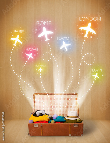 Photo: Travel bag with clothes and colorful planes flying out Travel bag with clothes and colorful planes flying out