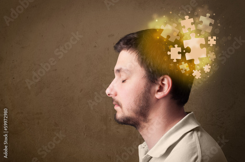 Photo: Young person thinking with glowing puzzle mind Young person thinking with glowing puzzle mind