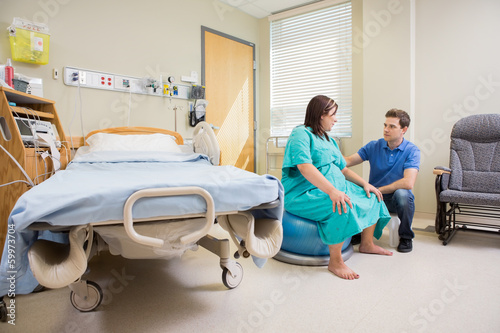 Photo: Man Looking At Pregnant Wife On Exercise Ball In Hospital Man Looking At Pregnant Wife On Exercise Ball In Hospital