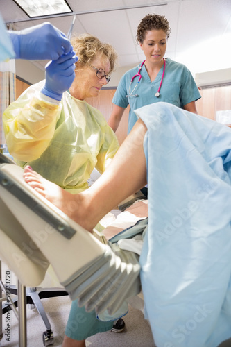Photo: Surgeon Receiving Scissors From Colleague While Delivering Baby Surgeon Receiving Scissors From Colleague While Delivering Baby