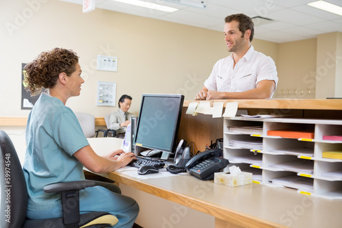 Photo: Nurse And Patient Conversing At Reception Desk Nurse And Patient Conversing At Reception Desk