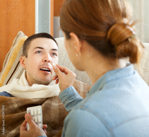 Photo: Wife giving pills to husband Wife giving pills to husband