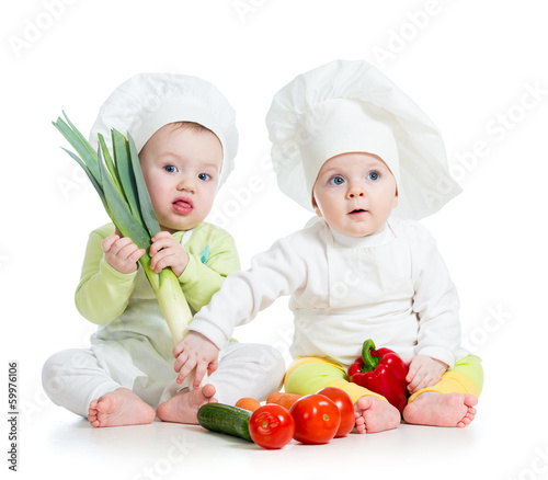 Photo: kids boy and girl wearing a chef hat with healthy food vegetabl kids boy and girl wearing a chef hat with healthy food vegetabl