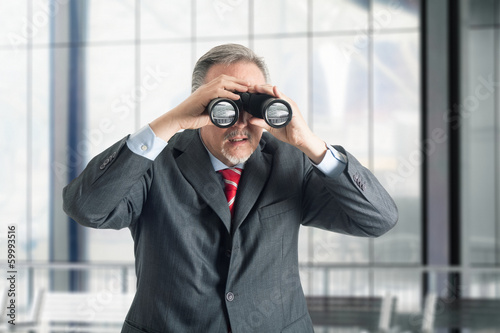 Photo: Businessman using binoculars Businessman using binoculars