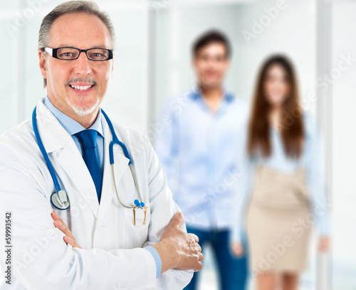 Photo: Doctor in front of a couple Doctor in front of a couple