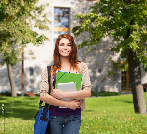 Photo: smiling student with bag, folders and tablet pc smiling student with bag, folders and tablet pc