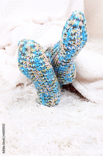 Photo: Female legs in colorful socks on white carpet background Female legs in colorful socks on white carpet background