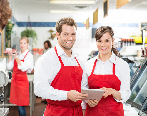 Photo: Butchers With Digital Tablet Standing In Store Butchers With Digital Tablet Standing In Store