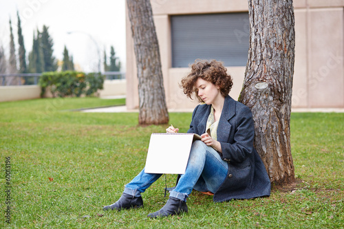 Photo: Female redhead art student drawing outdoors Female redhead art student drawing outdoors