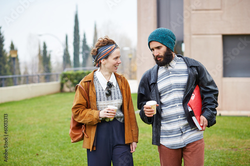 Photo: Hipster couple talking and drinking coffee to go Hipster couple talking and drinking coffee to go