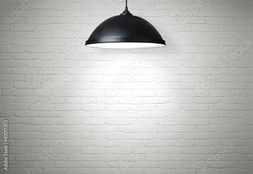Photo: White brick wall illuminated by the lamp with copy space White brick wall illuminated by the lamp with copy space