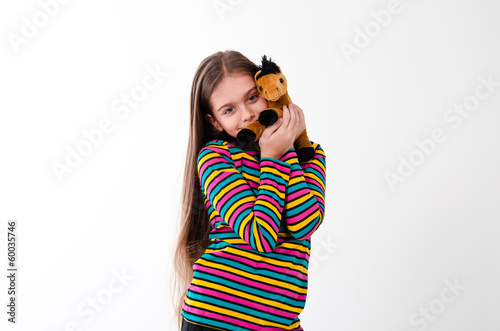 Photo: girl with long hair holding a toy horse girl with long hair holding a toy horse